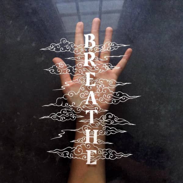 papercutting van woord ademen omgeven door papercut en weergegeven op open palm van handscrolls