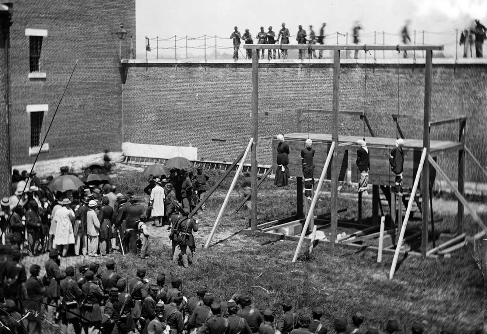 The hanging hooded bodies of the four conspirators, Mary Surratt, Lewis Powell (Payne), David Herold, and George Atzerodt, executed on July 7, 1865 at Fort McNair in Washington, District of Columbia, All four had been convicted of taking part in the conspiracy to assassinate Abraham Lincoln.