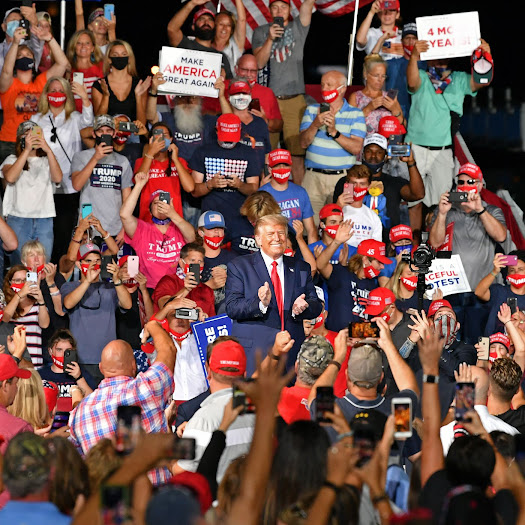 Picture of Donald Trump at a rally surrounded by cheering white people.