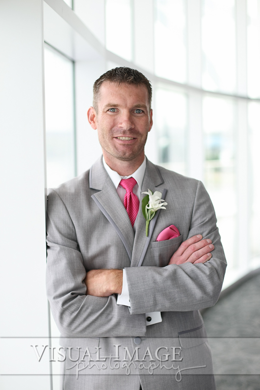 Groom wearing gray suit with pink tie