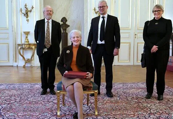 The National Museum presented a special edition of the museum's yearbook Nationalmuseets Arbejdsmark to Queen Margrethe. gold brooch