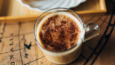 Coffee cup, donuts, camera, table Coffee cup, donuts, camera, table