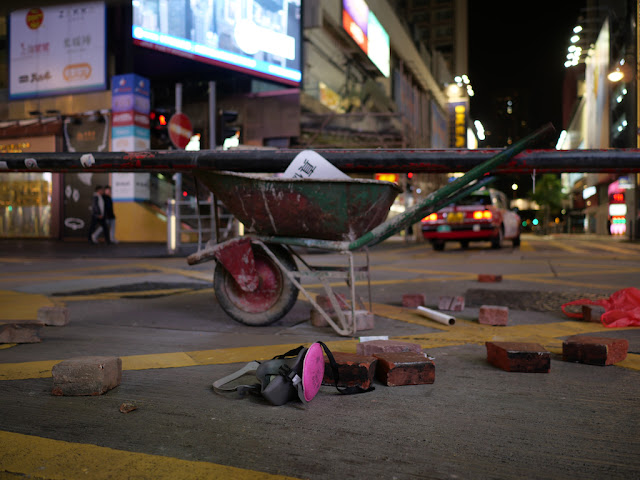 face mask, bricks, and wheelbarrow on a street