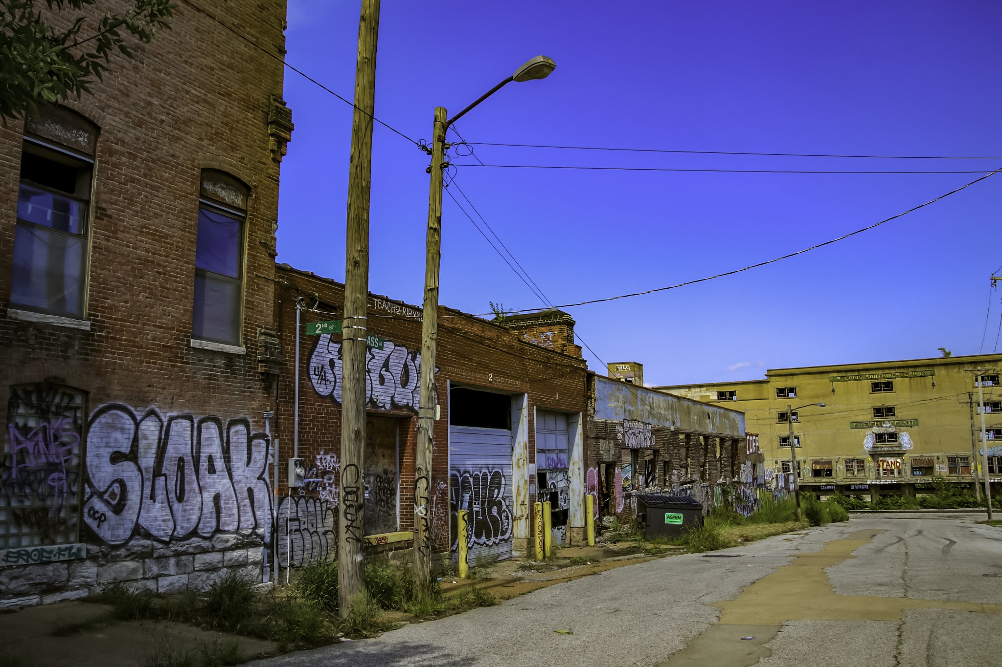 Abandoned brick buildings with graffiti on them under bright blue skies