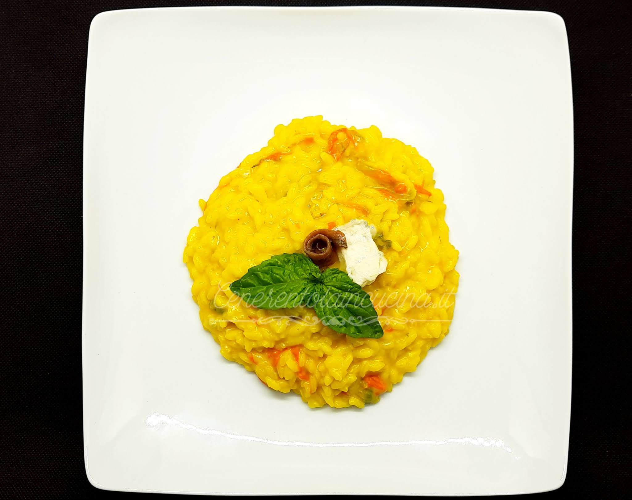 Risotto allo zafferano con fiori di zucca e acciughe.