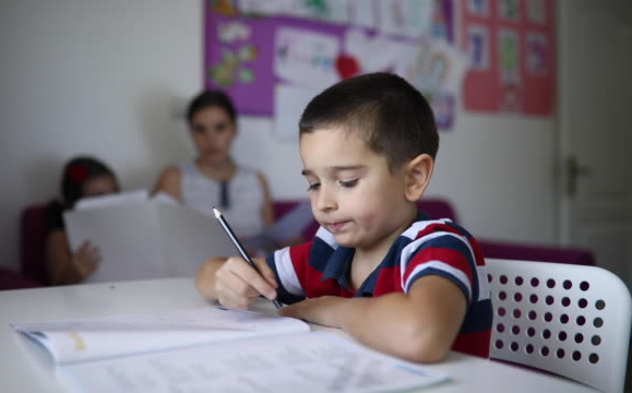 Aluno com tdah pode ser reprovado? o que diz a lei Aluno menino com tdah fazendo atividade escolar para casa