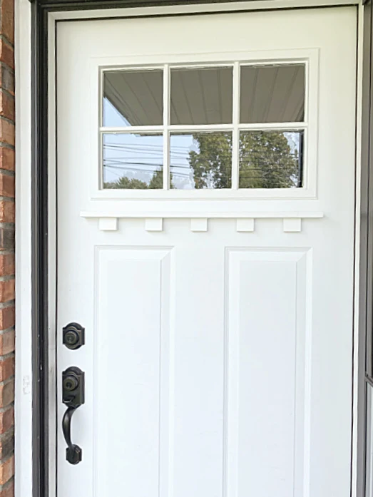 white front door with dentil shelf