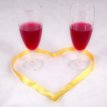 Walentynkowa randka - Dwie lampki czerwonego wina w sercu ze złotej wstążki