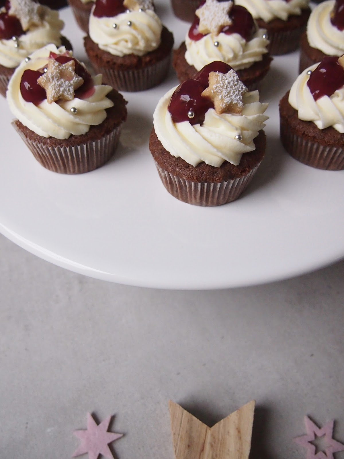 dieZuckerbäckerei LebkuchenSchokoladenCupcakes mit einem FrischkäseFrosting und Glühweinkirschen