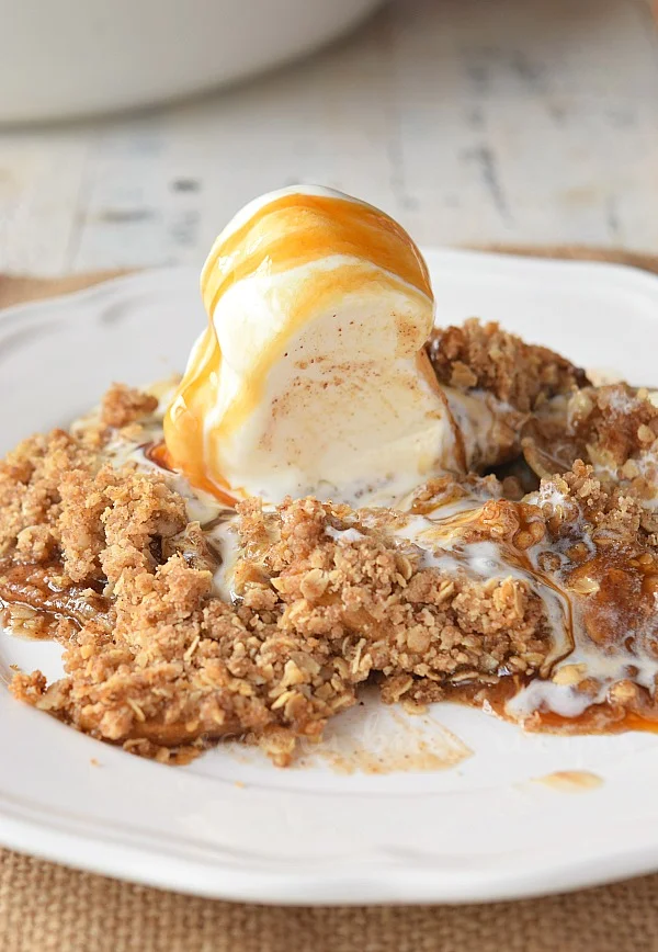 scooped ice cream with apple crisp on  a white plate