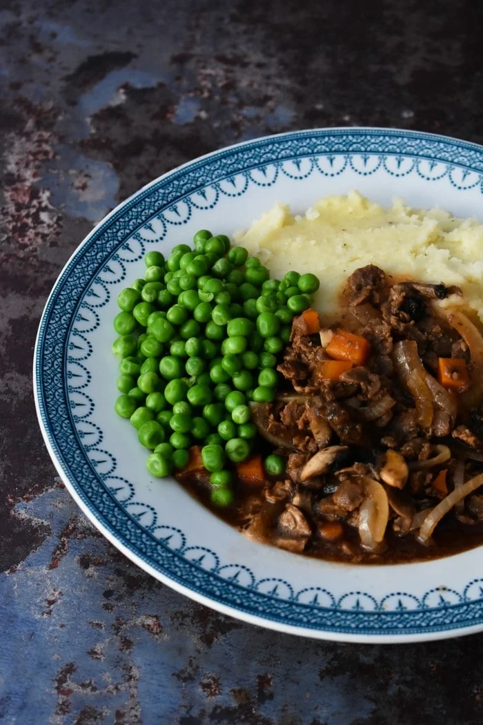 Close up of Slow Cooker Vegan Savoury Mince served with mash and peas
