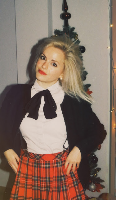 Alejandra Colomera con lazo negro en el cuello, camisa, blanca, chaqueta negra y falda tartán roja