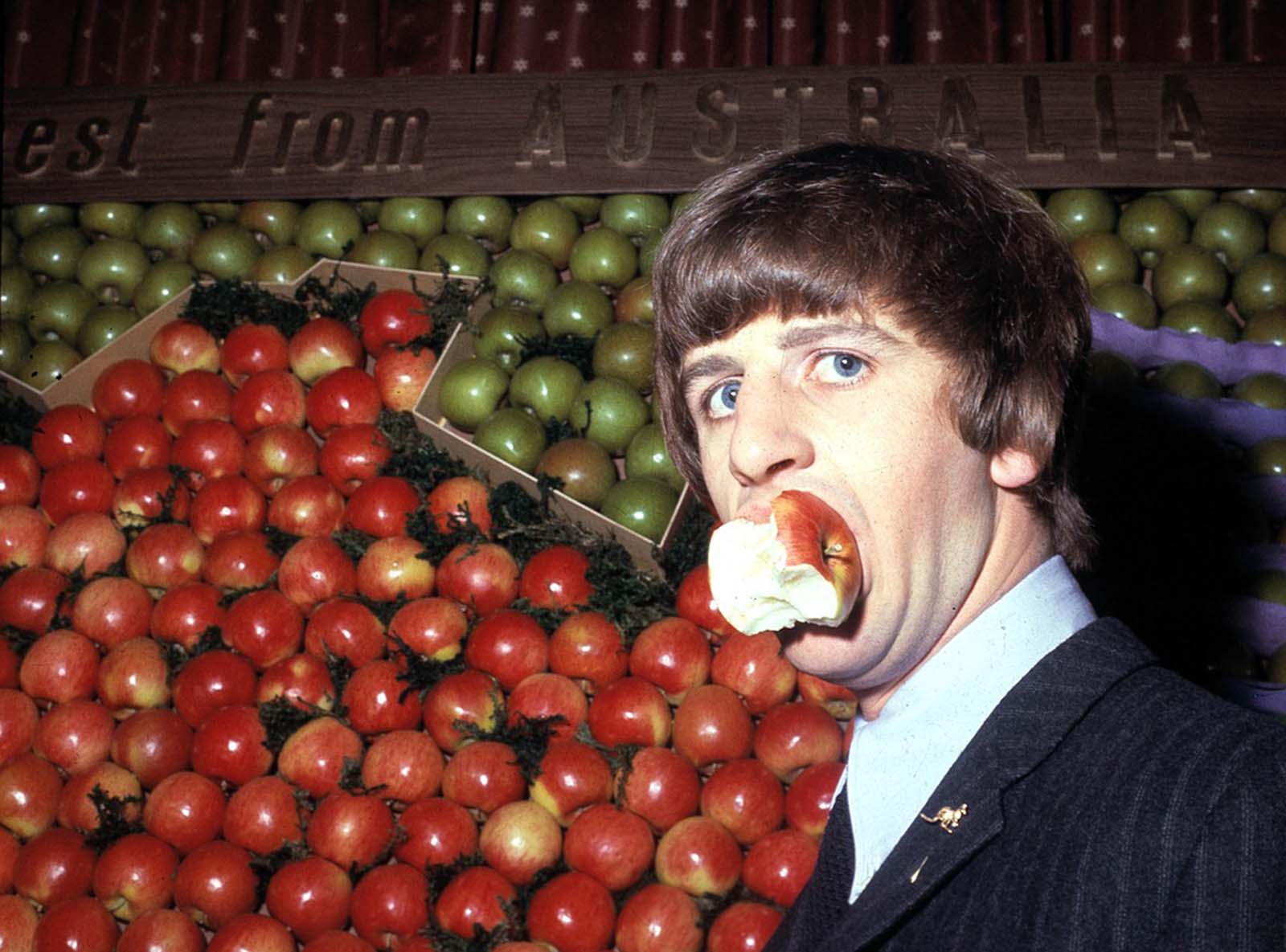 Ringo Starr samples an apple during a visit to Australia House in London, England, in 1964.