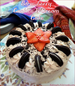Strawberry Cookies and Cream Cake is studded with crushed cookies and chopped strawberries, then topped with a strawberry cream frosting and sprinkled with more crushed cookies. | Recipe developed by www.BakingInATornado.com | #recipe #dessert