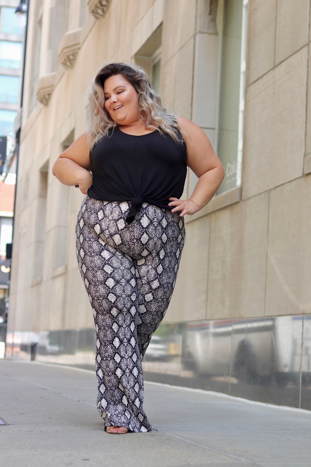 Chicago Plus Size Petite Fashion Blogger, influencer, YouTuber, and model Natalie Craig, of Natalie in the City, reviews Chic Soul's snake skin bell bottoms and basic black tank top.