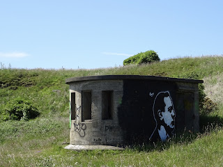Abandoned concrete WWII Pillbox with graffiti on wall of a man's face in side profile.  Photo by Kevin Nosferatu for the Skulferatu Project.