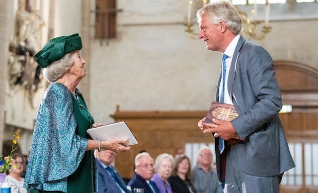The Princess wore a green embroidered skirt suit, embroidered cape and green hat, gold brooch