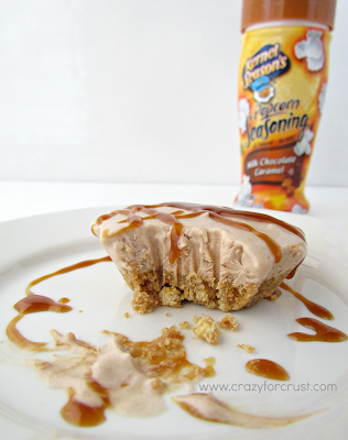 skinny milk chocolate and caramel freezer pie, with a missing bite,  on a white plate with popcorn seasoning bottle