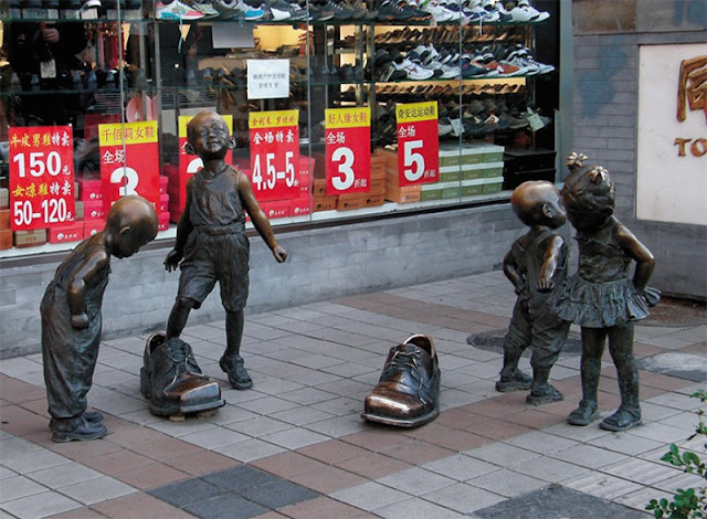 На улице Ванфуцзин немало небольших сюжетных скульптурных композиций, являющих прохожим былые странички жизни этого квартала. А эта живая сценка служит и эффектной рекламой обувного магазина