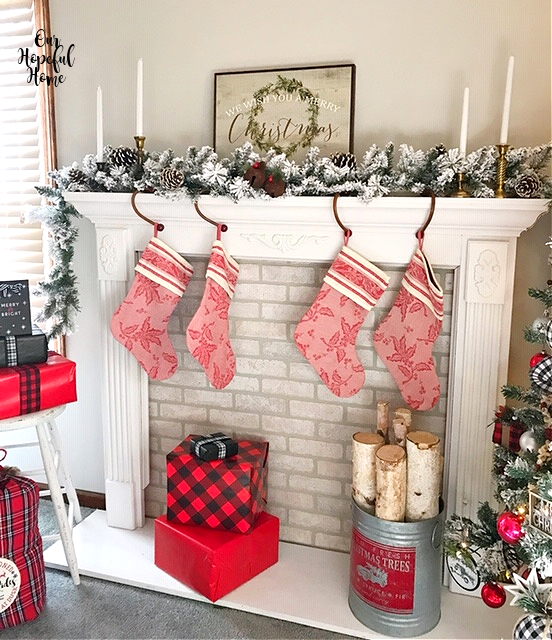 red toile Christmas stocking fireplace wrapped Christmas gifts birch logs