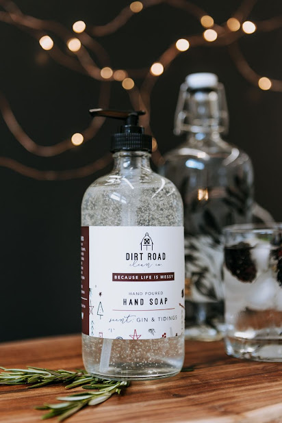 Glass bottle of hand soap with twinkle lights and rosemary