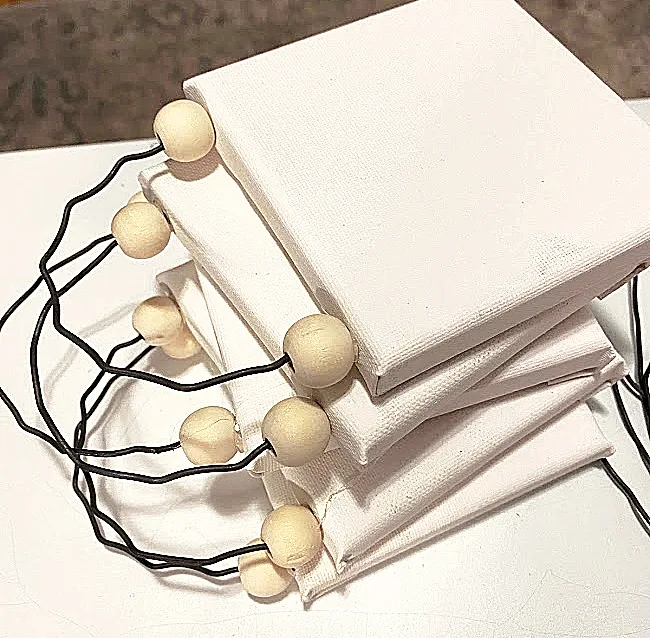 stack of mini canvases with beads and wire
