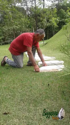 Bizzarri, da Bizzarri Pedras, trabalhando, iniciando a execução dos caminhos de pedra no jardim sendo o tipo de caminho com pedra com junta de grama em casa em condomínio em Mairiporã-SP.