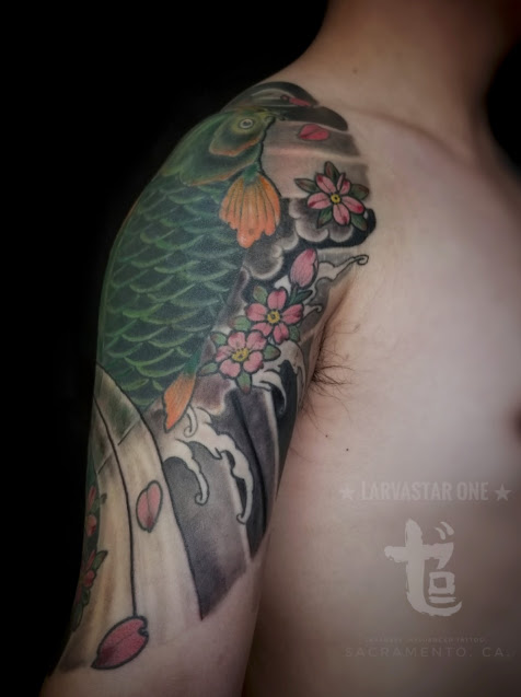 green koi fish with waves and cherries blossom on a man arm done at zero one ink Sacramento California