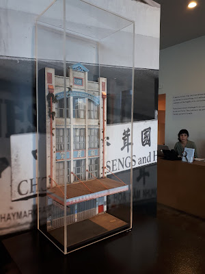 1/24 scale model facade of an old four-storey commercial building on display in an art gallery,.