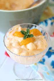Orange fruit salad with marshmallows in glass dish