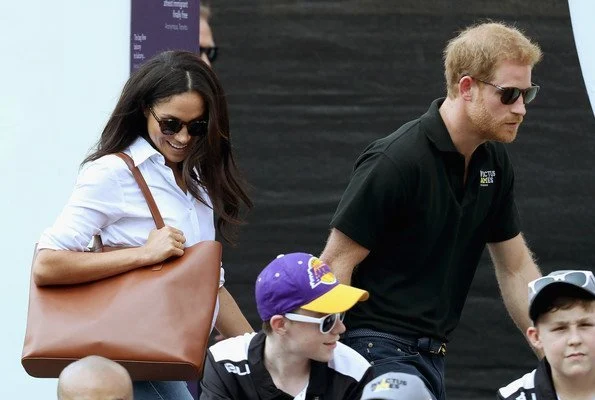 Prince Harry and Meghan Markle watched Wheelchair Tennis match. Style of Meghan Markle. wore a ice blue blouse and jeans