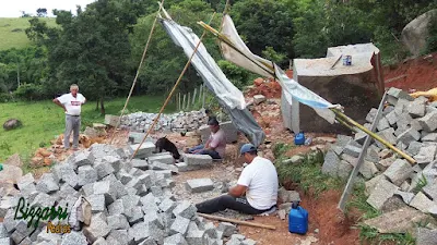 Bizzarri fazendo o que gosta, garimpando pedras na pedreira. Na foto escolhendo pedra folheta de granito cinza claro e pedra paralelepípedo cinza claro. Pedra para parede de pedra, calçamento de pedra, pedras para revestimento de pedra, muro de pedra, escada de pedra e pedras para caminho de pedra no jardim.