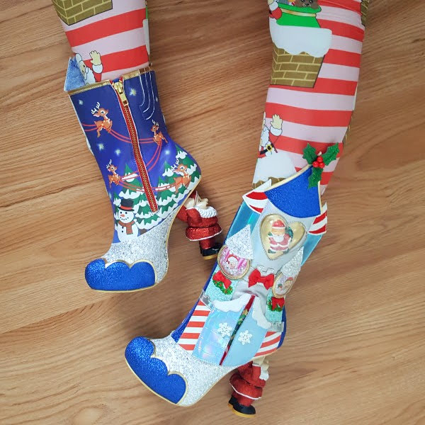 legs in striped Christmas tights showing deer print inner side of boot and castle themed outer side