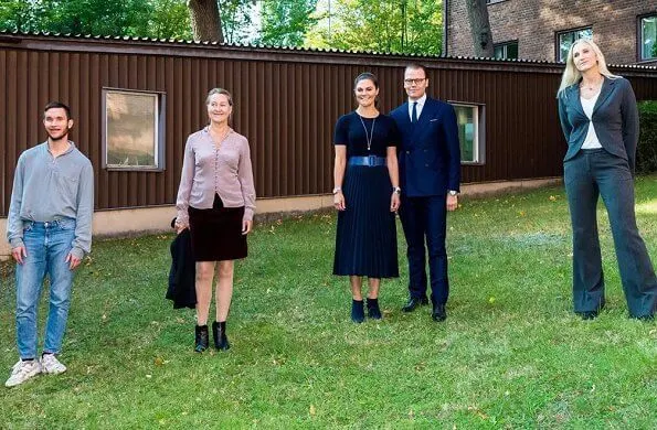 Crown Princess Victoria wore new pleated skirt from HM, navy duchess earrings from Ebba Brahe, and Rakel navy blue boots from af Klingberg