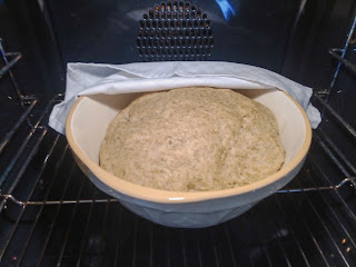 Same bowl with the napkin pulled back to reveal that the dough has doubled in size.