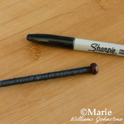 Black Sharpie pen and black knitting needle