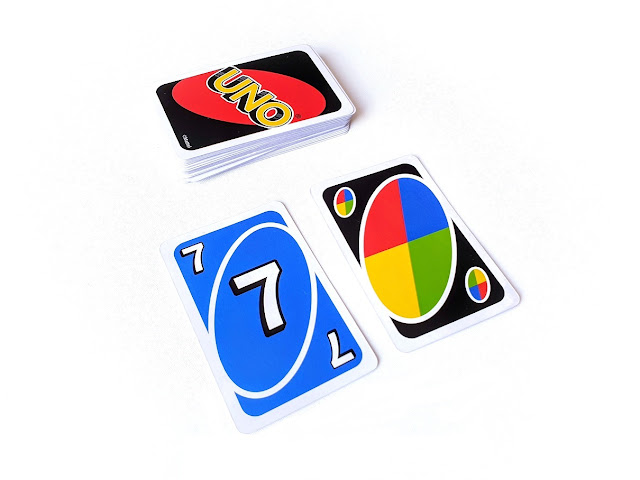 Nauka dopełniania do 10, zdjęcie przedstawia zakryty stos kart i leżące przed nim niebieską siódemkę i kartę specjalną joker