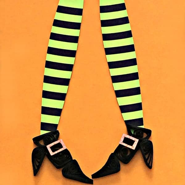 quilled witch legs wearing striped black and green stockings with buckled booties