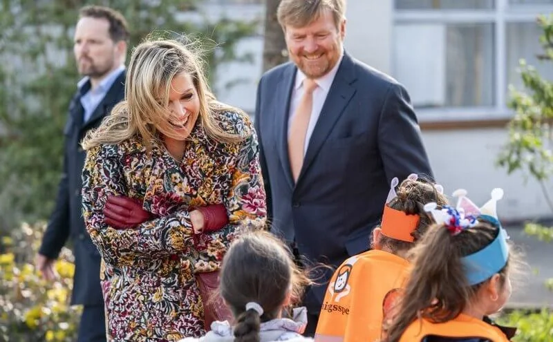 Queen Maxima wore a floral brocade long coat from Oscar de la Renta, and red LaPerm blazer, Lykoi trousers and Korat red blouse from Claes Iversen