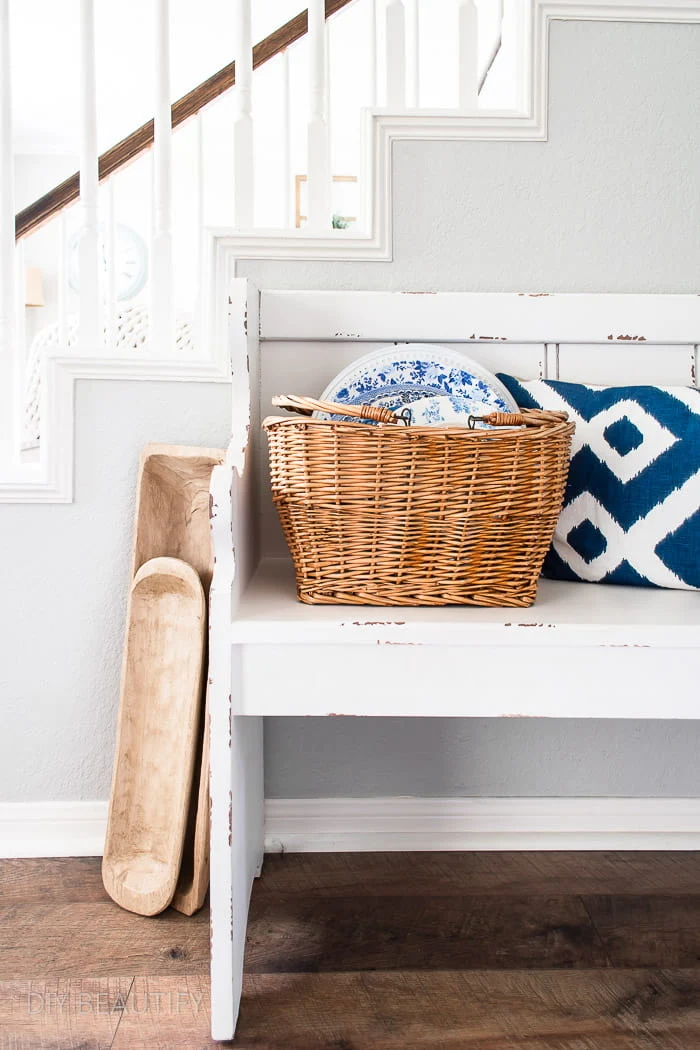 farmhouse bench, dough bowls and basket filled with dishes