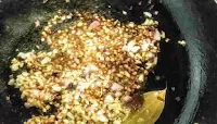 Frying whole spices and onion for making chole