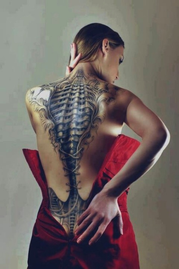 Chica con tatuaje 3d en la espalda que parece un corse de piel y debajo se ven las costillas que son de metal