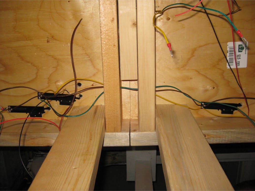 Atlas under table switch machines with wiring installed below wooden benchwork