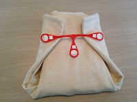 Image; Use cloth diaper pins or a Snappi(r) to fasten diaper securely