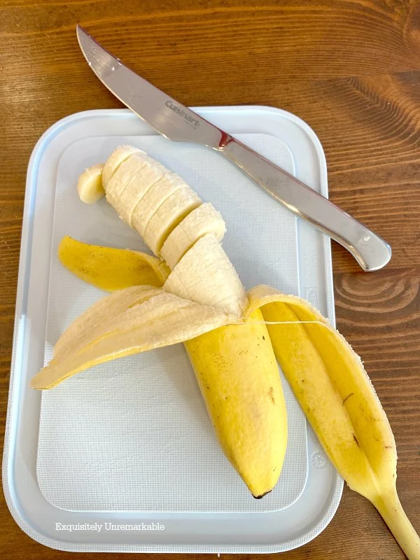 Sliced Banana on a blue cutting board with a knife
