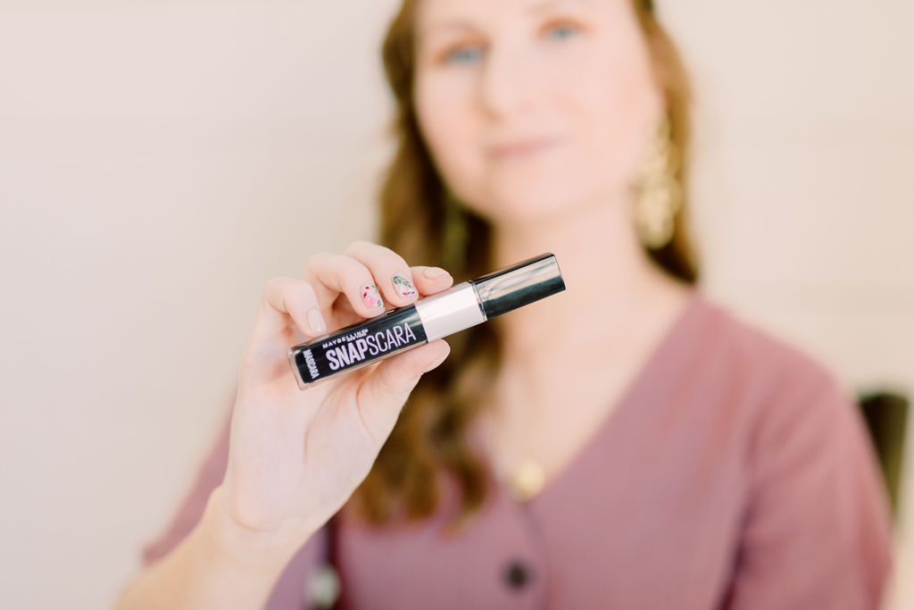 blogger amanda burrows is holding out a bottle of snapscara from maybelline