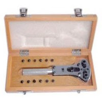 Wide watch case wrench in wooden box with assorted pins