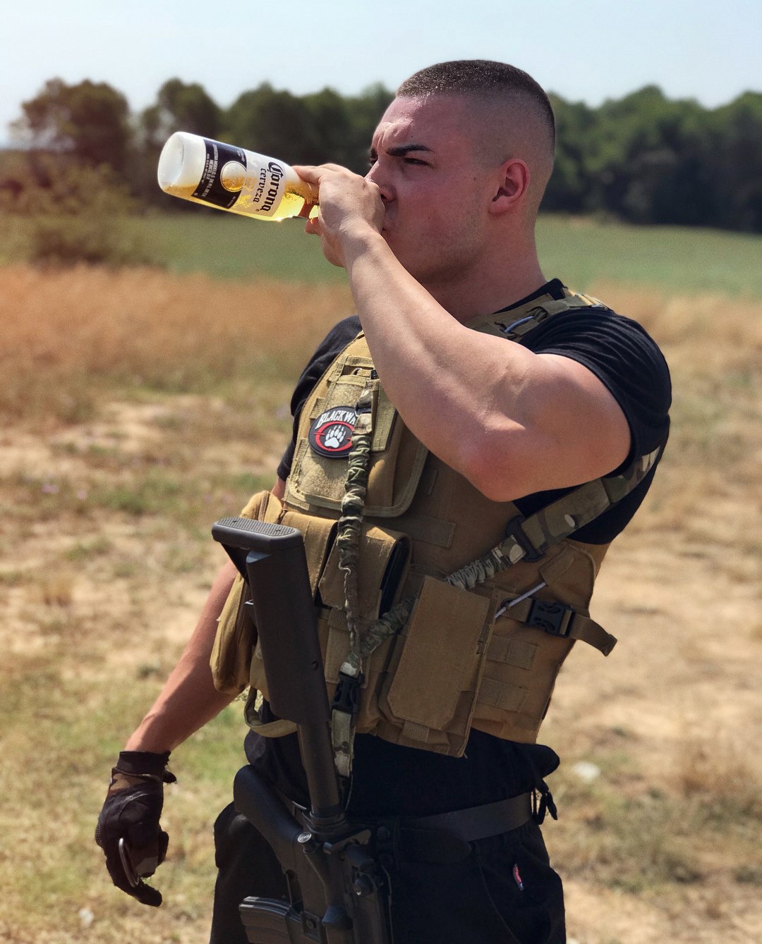 mad-armed-young-man-uniform-drinking-corona-gun-shooter-masculine-alpha-bro-type