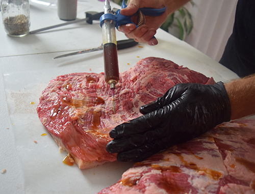 Injecting a beef brisket with Butcher's Original Brisket Injection.
