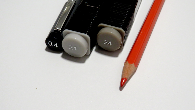 Rotulador calibrado del 0.4, rotulador a base de alcohol de la marca Tiger en la numeración 21 y 24 y un lápiz rojo
